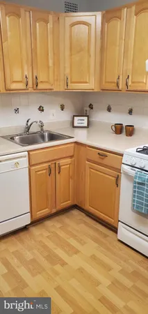 a kitchen with stainless steel appliances granite countertop a sink a stove and white cabinets