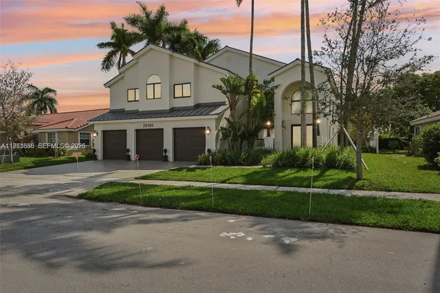 a front view of a house with a yard and potted plants