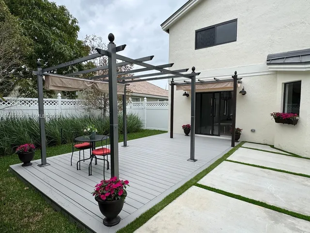 an empty room with wooden floor a ceiling fan and windows