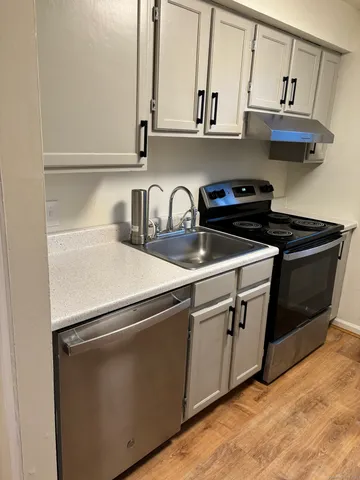 a kitchen with stainless steel appliances granite countertop a sink and a stove
