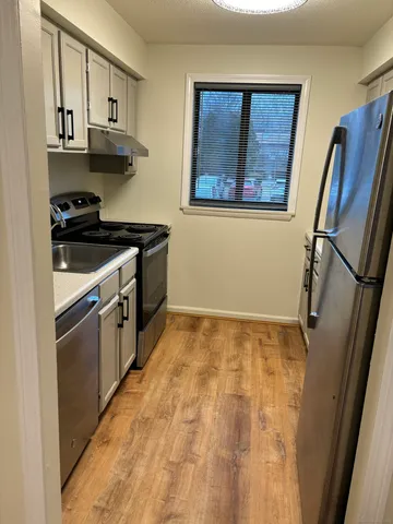 a kitchen with stainless steel appliances a stove a refrigerator and cabinets