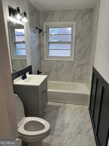 a bathroom with a toilet a sink and bathtub