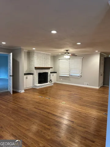 an empty room with wooden floor and fireplace