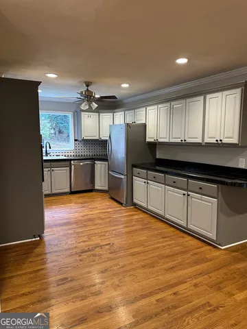 a large kitchen with granite countertop a stove and cabinets