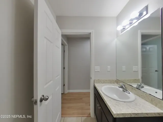 a bathroom with a granite countertop sink a mirror and vanity