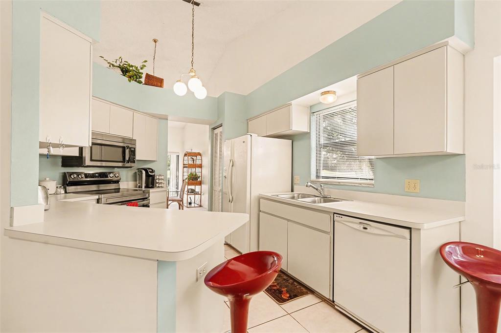 9130 Bassett Lane New Port Richey, FL 34655 - Photo 16 of 41 a kitchen with stainless steel appliances kitchen island granite countertop a sink a stove and a refrigerator