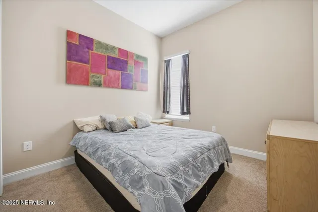 a bedroom with a bed and a painting on the wall