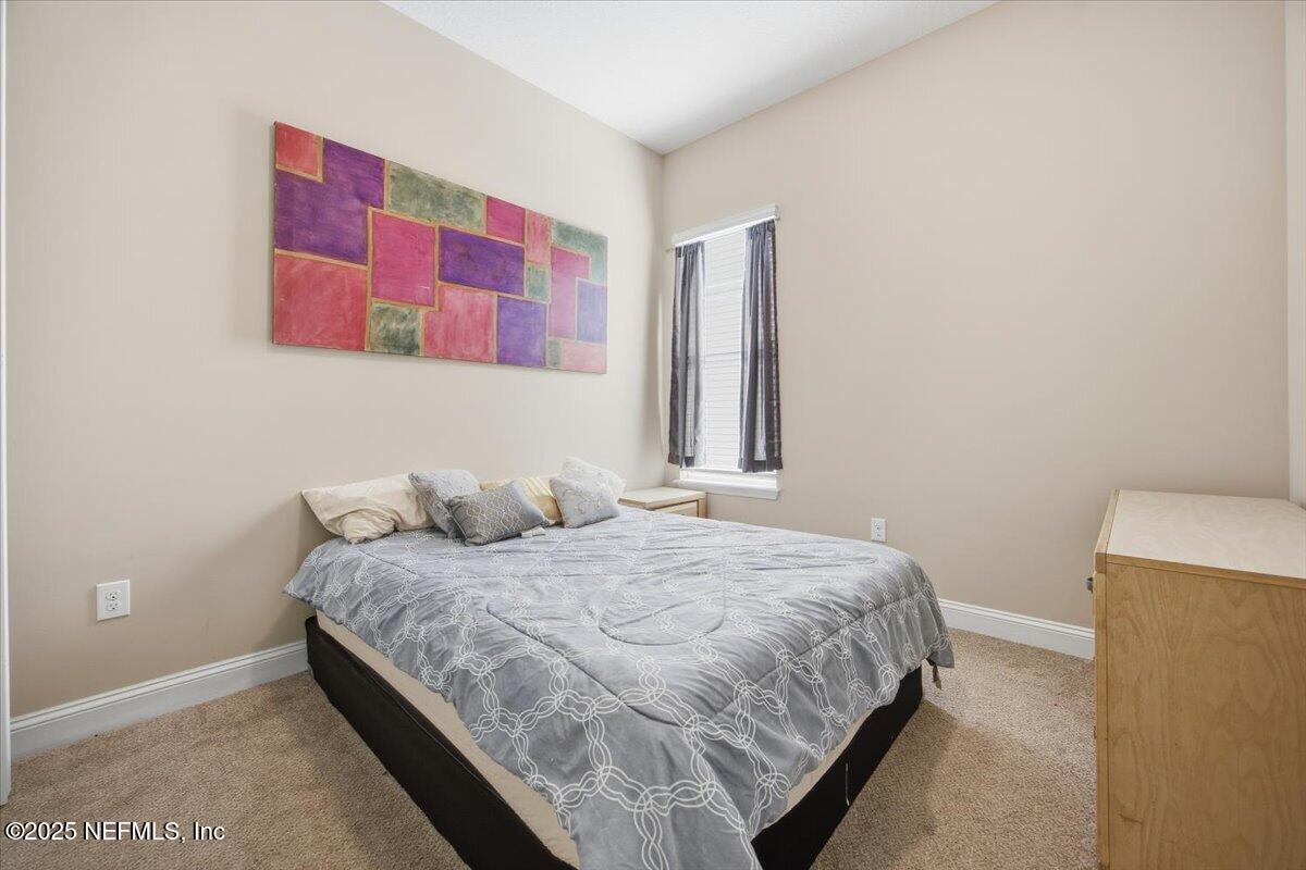 230 Julep Street Yulee, FL 32097 - Photo 12 of 24 a bedroom with a bed and a painting on the wall