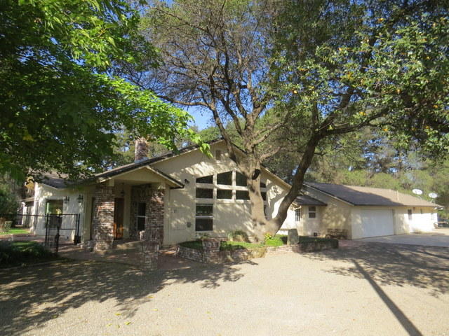17410 Bowman Road Cottonwood, CA 96022 - Photo 2 of 24 a front view of a house with a yard covered with snow and trees