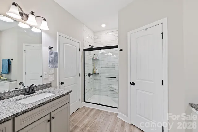 a bathroom with a granite countertop sink mirror and shower