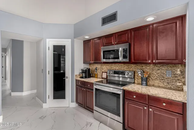 a kitchen with granite countertop a sink dining table and chairs