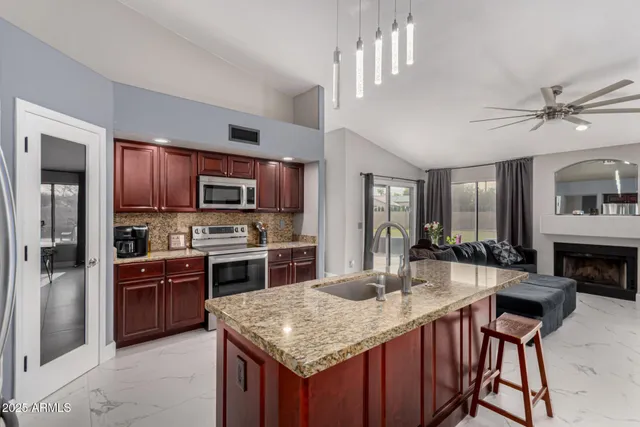 a kitchen with stainless steel appliances granite countertop a stove top oven a sink dishwasher a dining table and chairs