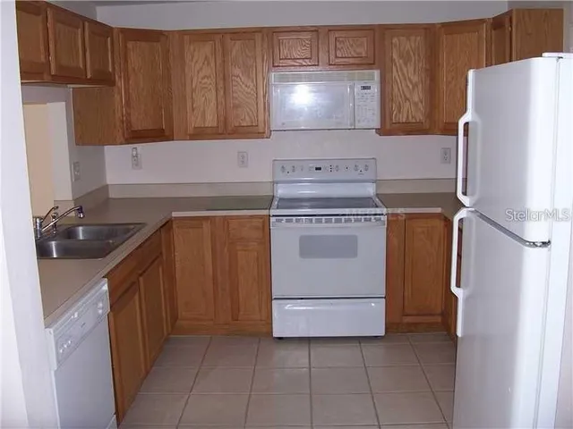 a kitchen with a stove sink and cabinets