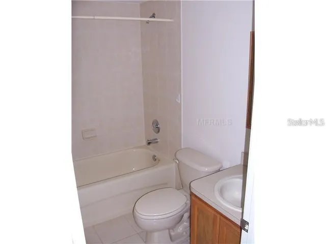 a white toilet sitting next to a bath tub