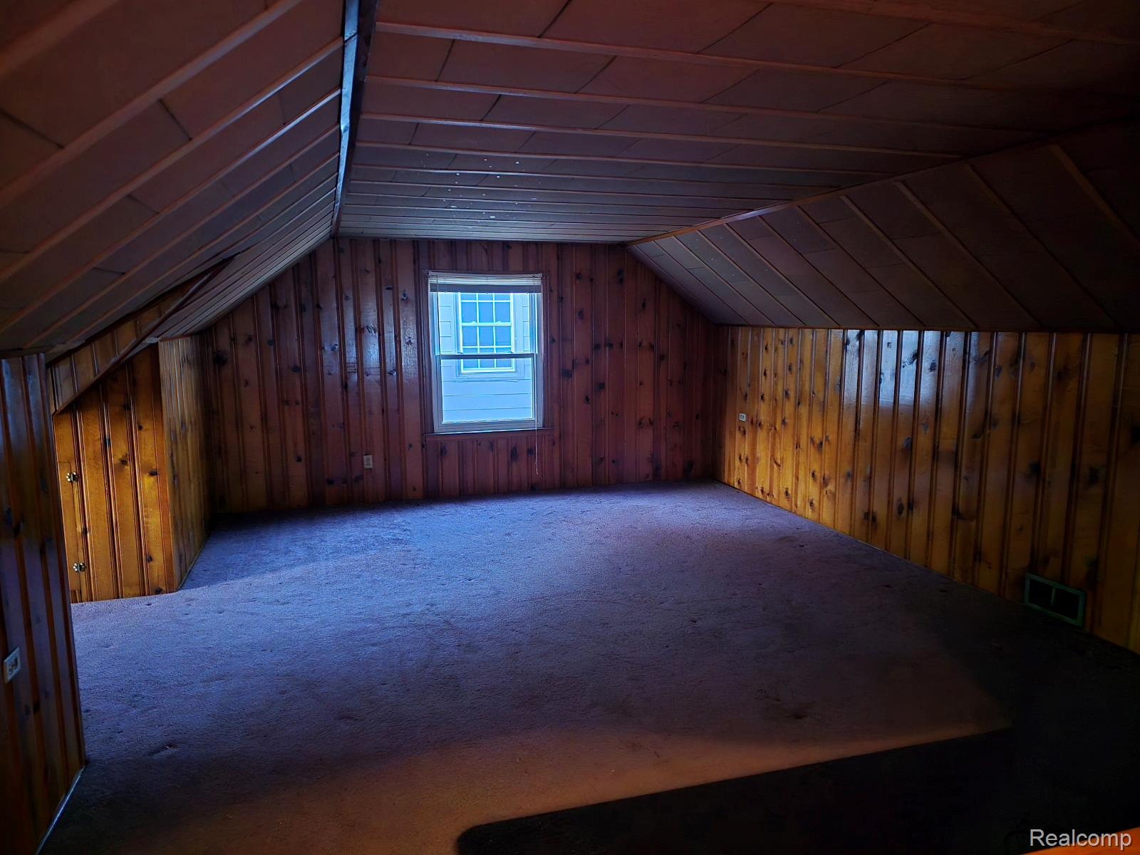 803 Commonwealth Avenue Flint, MI 48503 - Photo 14 of 15 Bonus room with carpet, wood walls, and vaulted ceiling