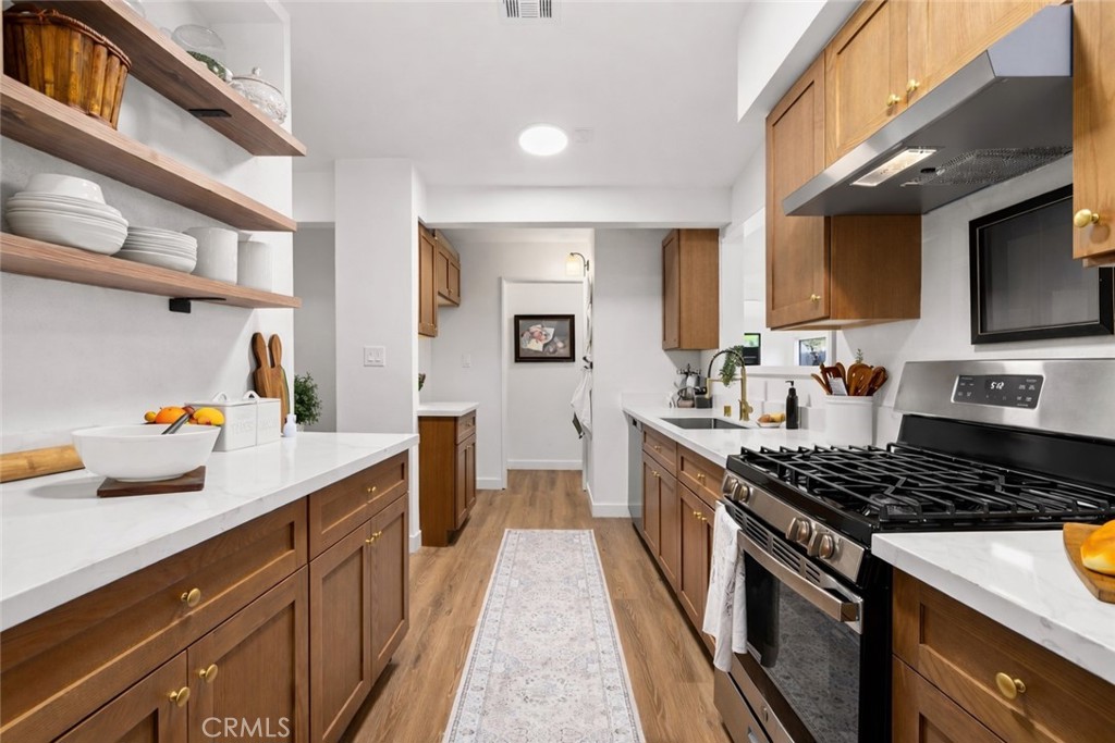 249 Alru Street Rialto, CA 92376 - Photo 5 of 33 Galley-style kitchen with ample cabinetry, counter space, and natural light