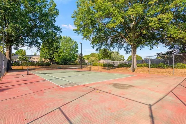 a basketball court with trees in the background
