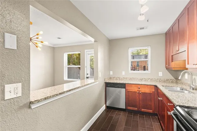 a view of a kitchen with a sink wooden cabinets and outdoor space