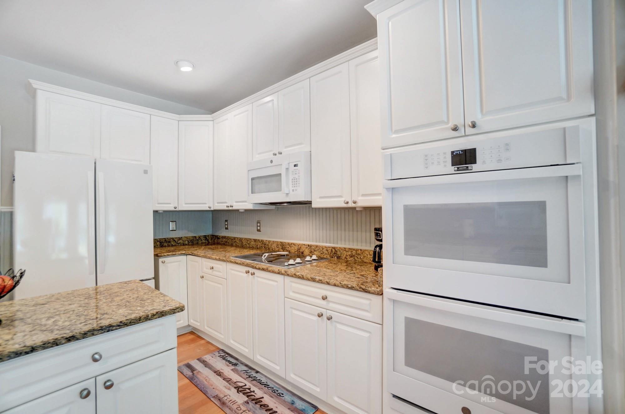8387 Fairfield Forest Road Denver, NC 28037 - Photo 13 of 38 a kitchen with granite countertop white cabinets and white appliances