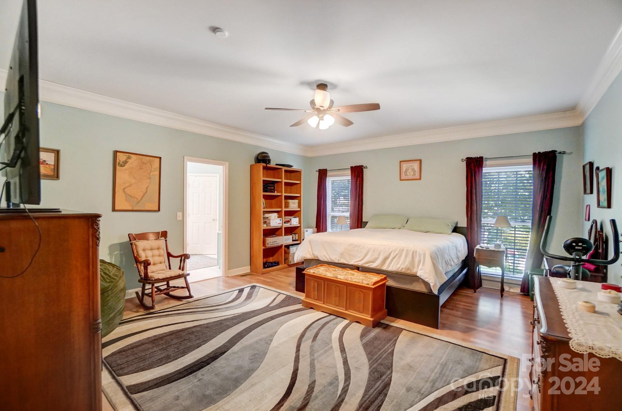 8387 Fairfield Forest Road Denver, NC 28037 - Photo 19 of 38 a spacious bedroom with a bed a dresser and a chandelier