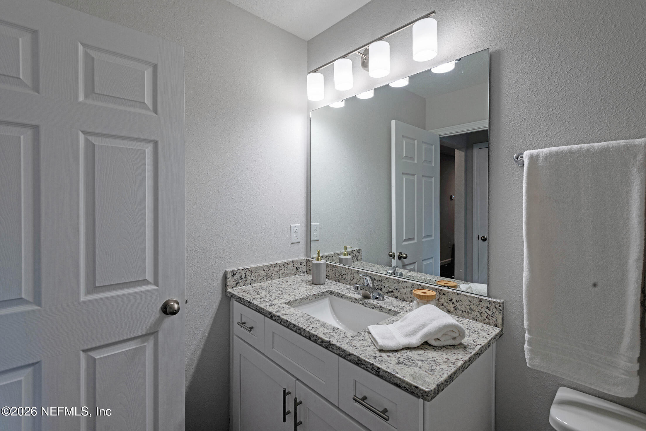 13611 Benton Street Jacksonville, FL 32218 - Photo 30 of 32 a bathroom with a granite countertop sink and a mirror
