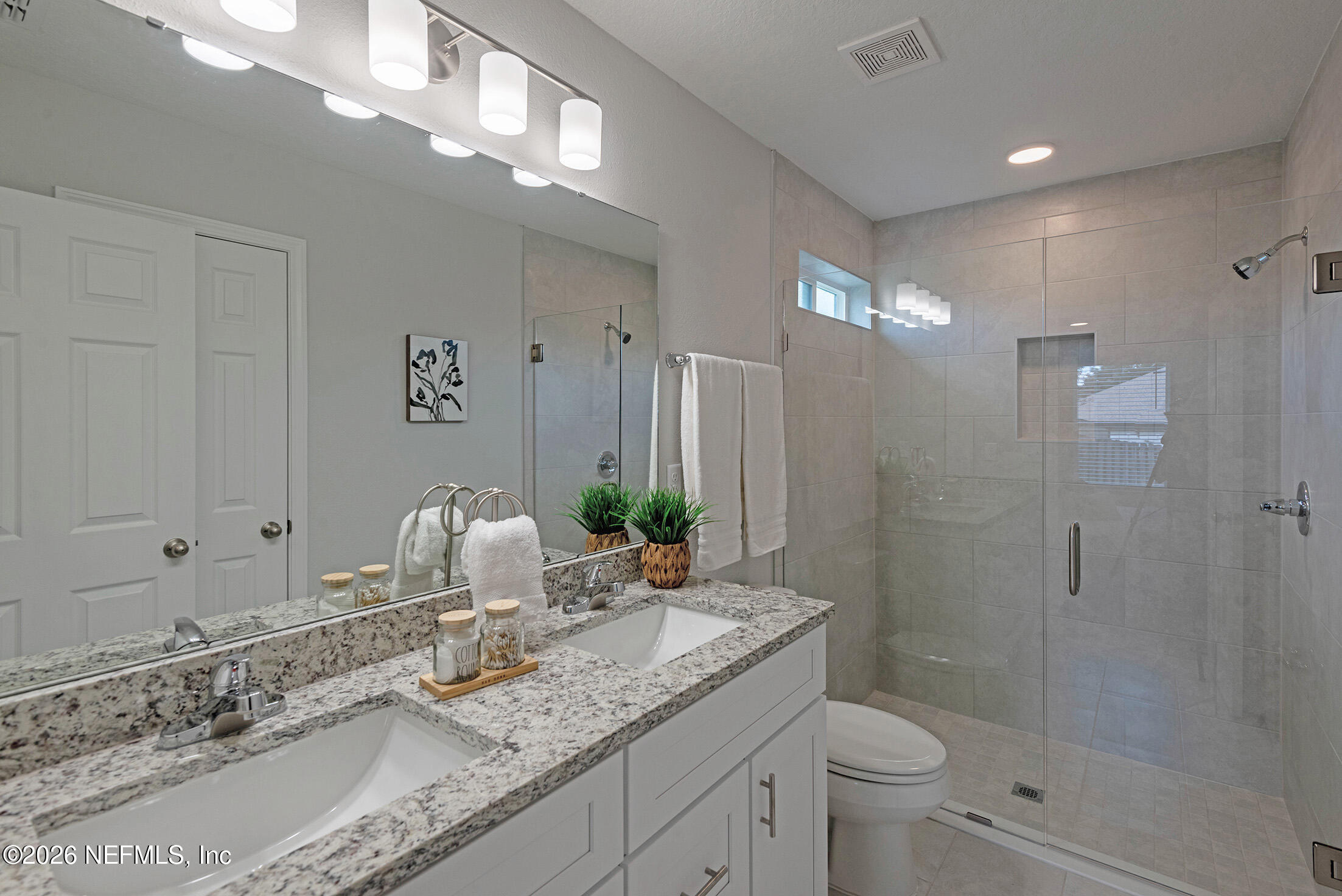 13611 Benton Street Jacksonville, FL 32218 - Photo 31 of 32 a bathroom with a granite countertop sink a toilet a mirror and shower