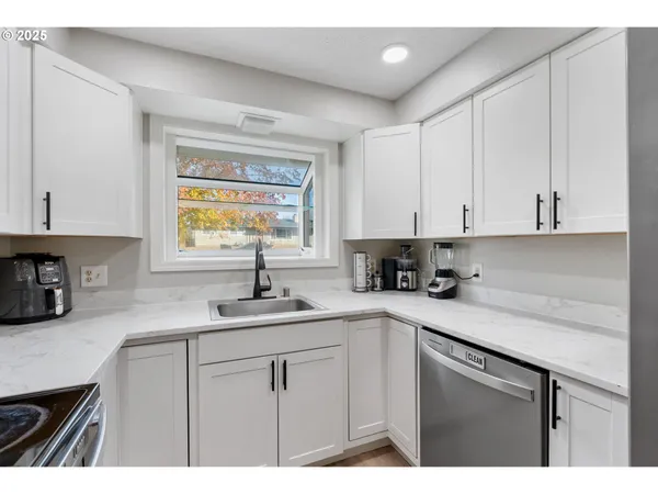 a kitchen with a sink cabinets and window