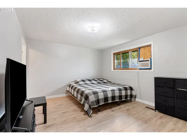 a living room with a bed furniture and a flat screen tv