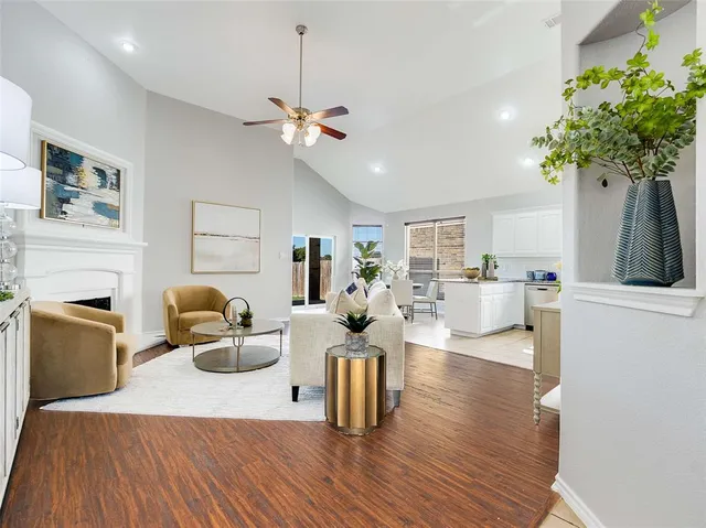 a living room with furniture a fireplace and a potted plant