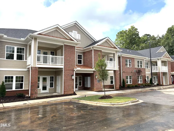 a front view of a residential apartment building with a yard