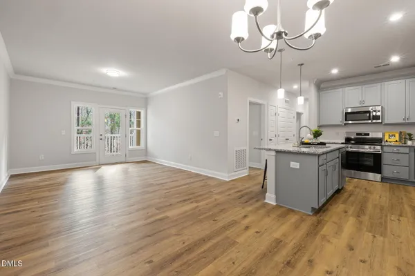 a view of kitchen with granite countertop stainless steel appliances cabinets a wooden floor and a fireplace