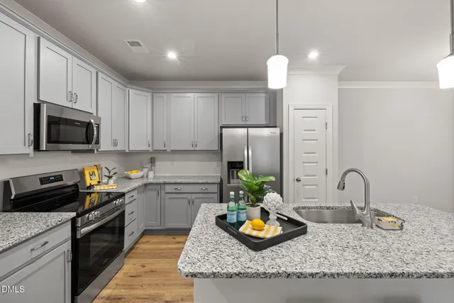 a kitchen with a refrigerator a stove and a sink