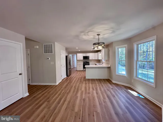 a view of empty room with wooden floor