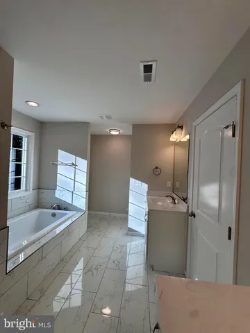 a bathroom with a double vanity sink toilet mirror and bathtub