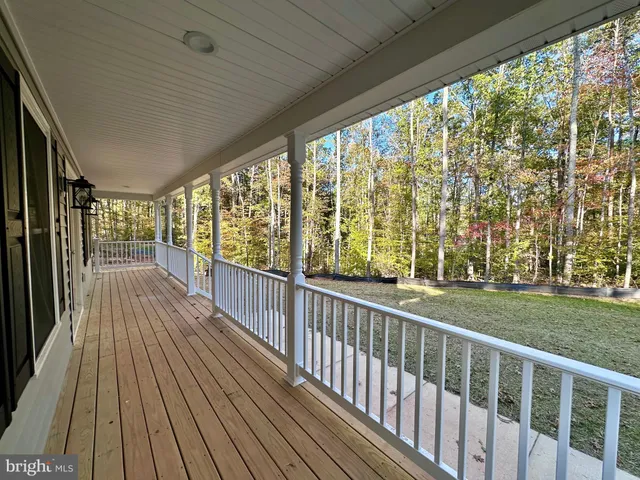 a kitchen with stainless steel appliances kitchen island granite countertop a refrigerator a sink a stove and oven with wooden floor