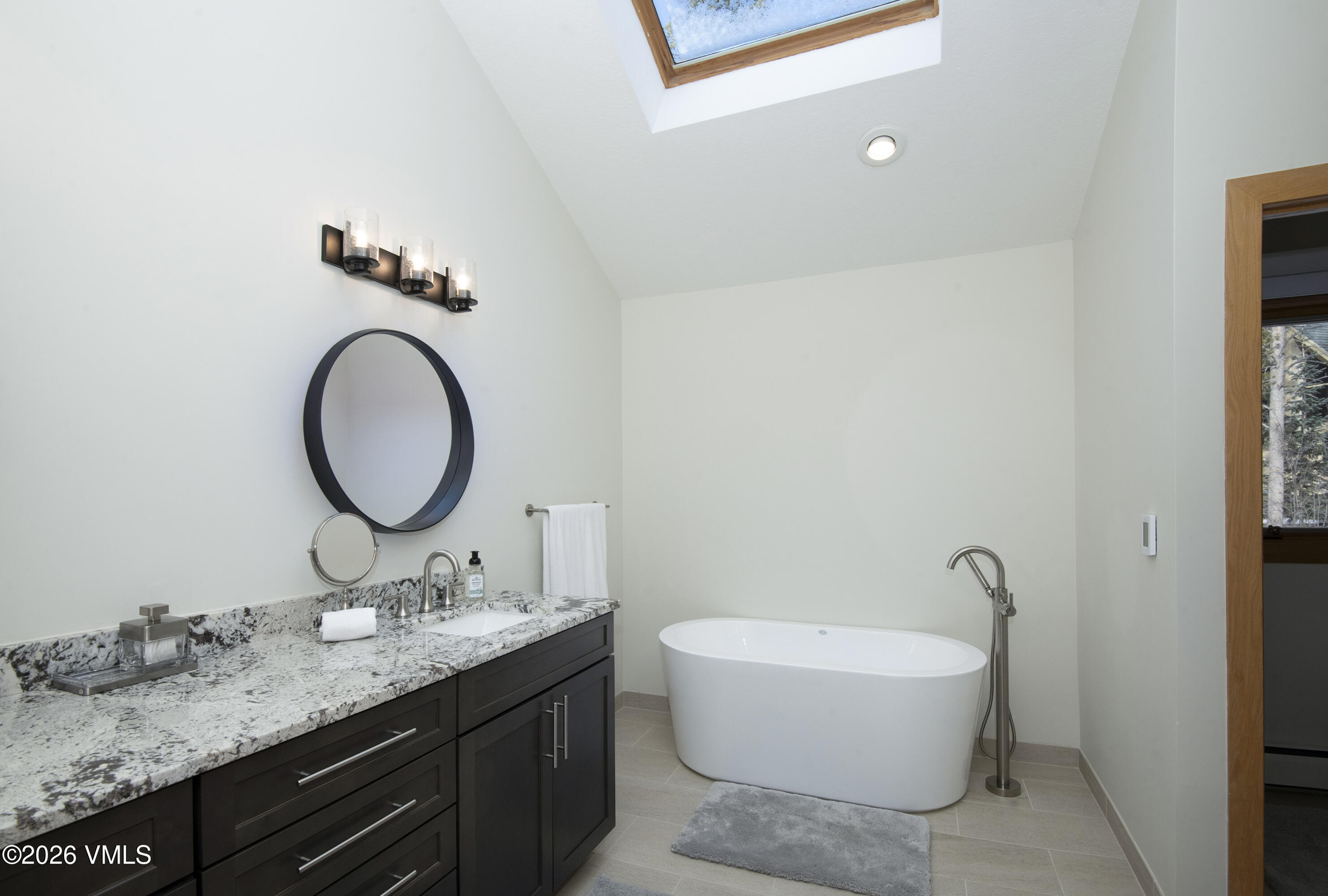 5159 Gore Circle Vail, CO 81657 - Photo 11 of 36 a bathroom with a granite countertop sink a toilet and a mirror