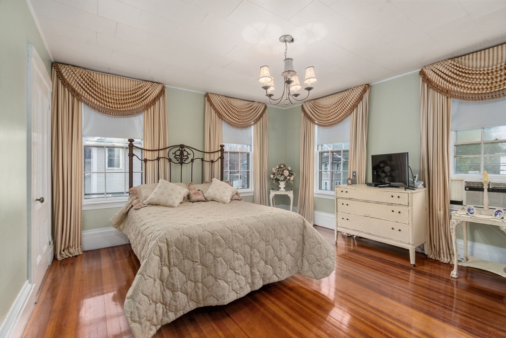 19 Winter Street Arlington, MA 02474 - Photo 13 of 39 a bedroom with a bed and a chandelier