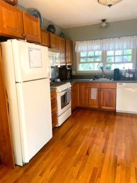 19 Winter Street Arlington, MA 02474 - Photo 33 of 39 a kitchen with granite countertop a refrigerator a stove a sink dishwasher and wooden cabinets with wooden floor