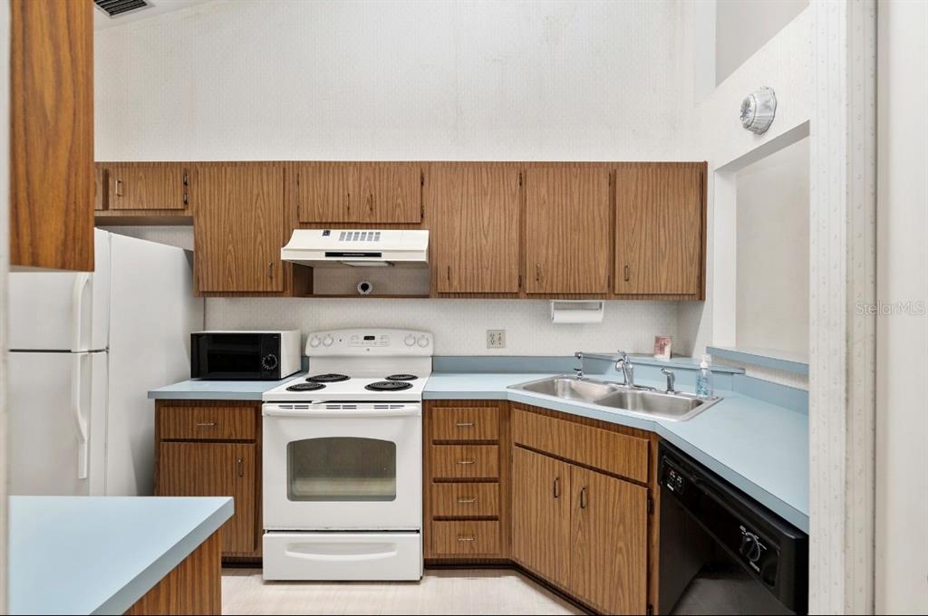 907 Southwest 51 Way Gainesville, FL 32607 - Photo 6 of 45 a kitchen with a stove a sink and a refrigerator