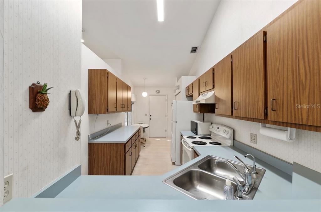 907 Southwest 51 Way Gainesville, FL 32607 - Photo 10 of 45 a kitchen with stainless steel appliances a sink a stove and a wooden cabinets