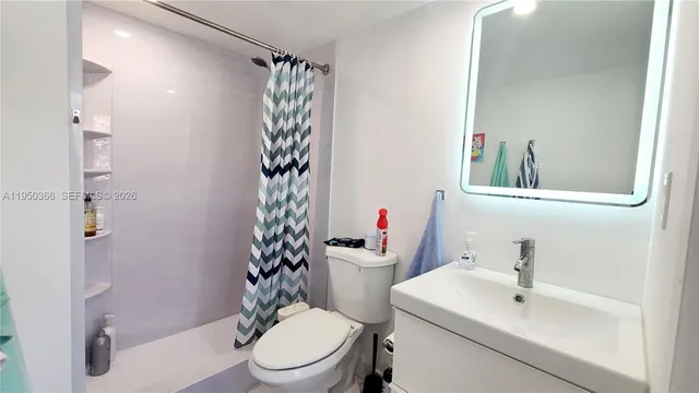 a white toilet sitting next to a bathroom sink