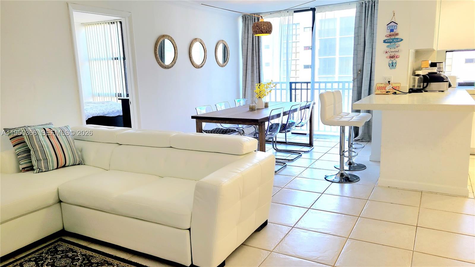 16909 North Bay Road, Unit 806 Sunny Isles Beach, FL 33160 - Photo 3 of 27 a living room with a couch and a table