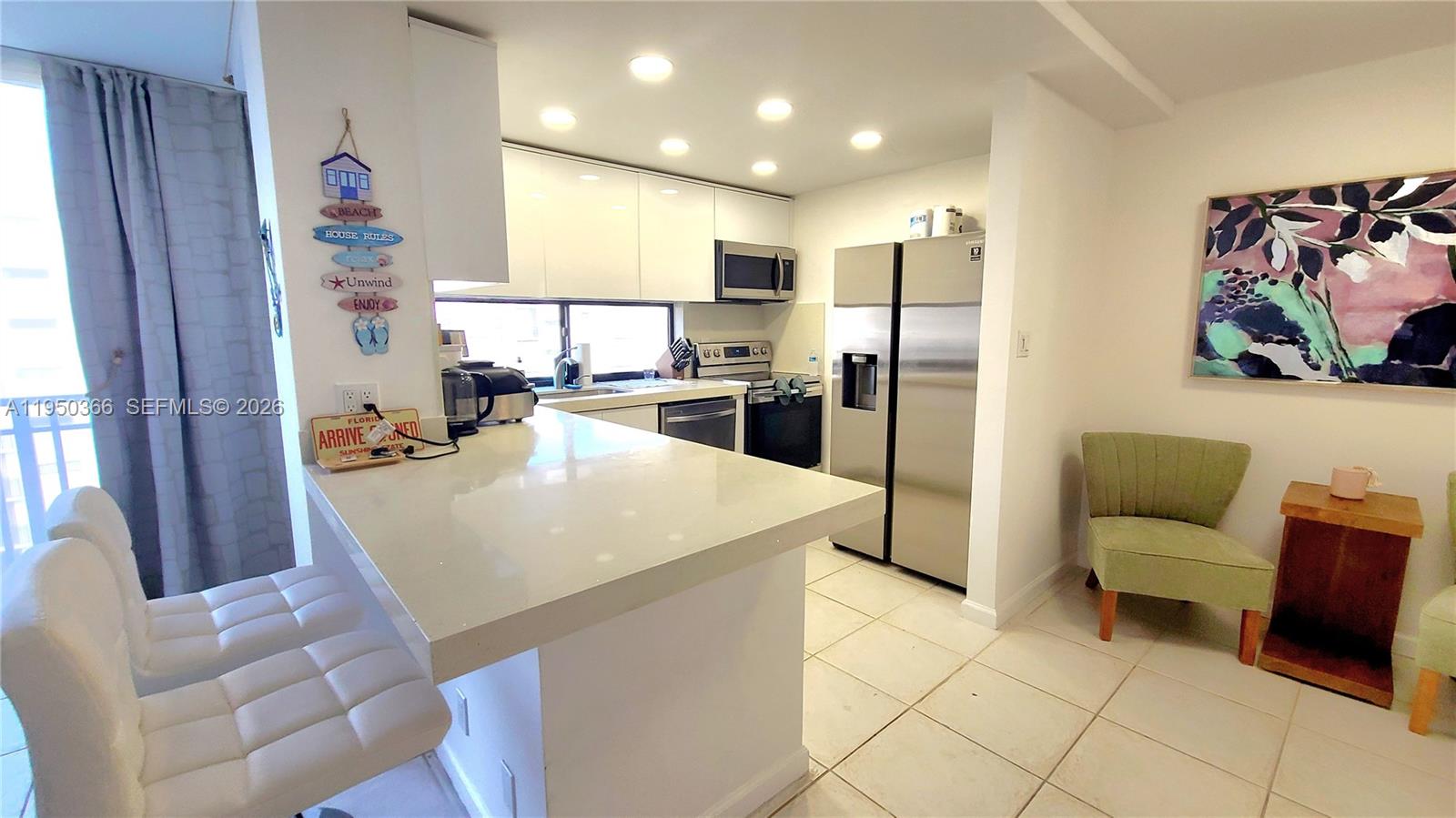 16909 North Bay Road, Unit 806 Sunny Isles Beach, FL 33160 - Photo 6 of 27 a kitchen with stainless steel appliances granite countertop a refrigerator and a living room