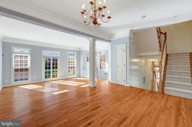 a view of a room with wooden floor and chandelier