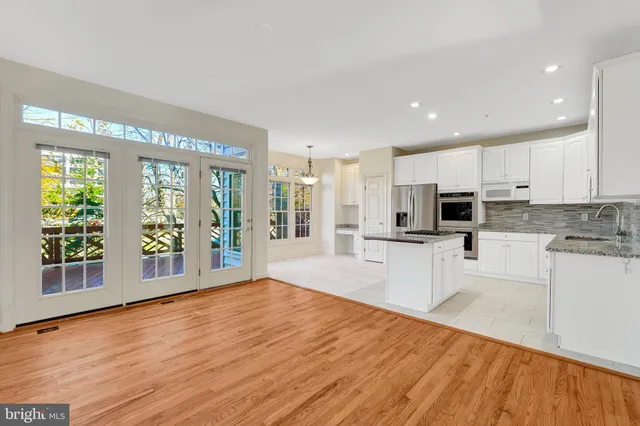 a kitchen with stainless steel appliances kitchen island granite countertop a refrigerator and a stove top oven