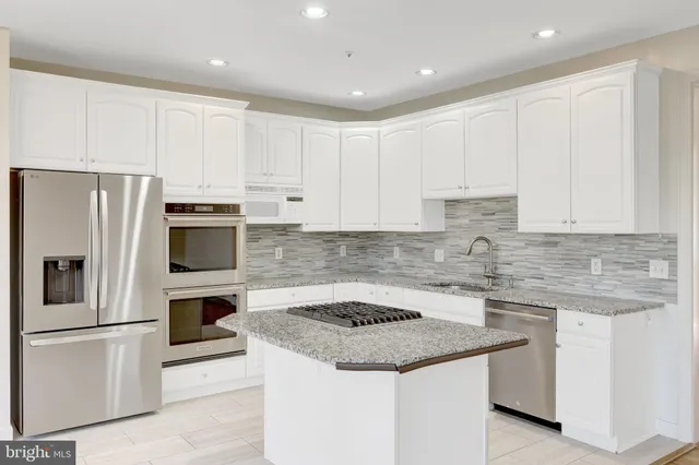a kitchen with stainless steel appliances granite countertop a sink stove and cabinets
