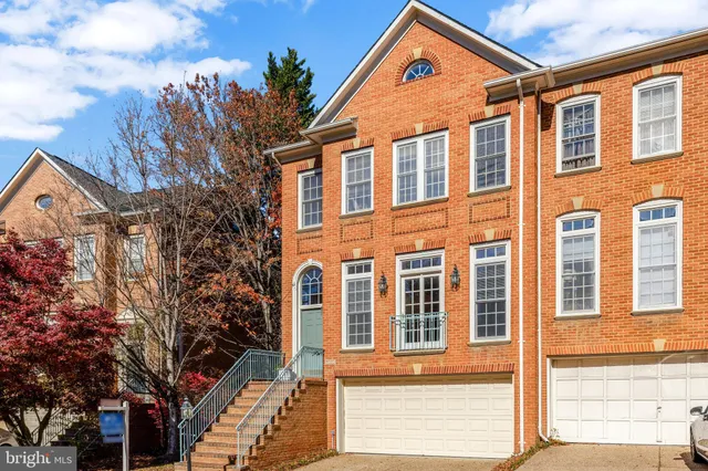 a front view of a house with a tree