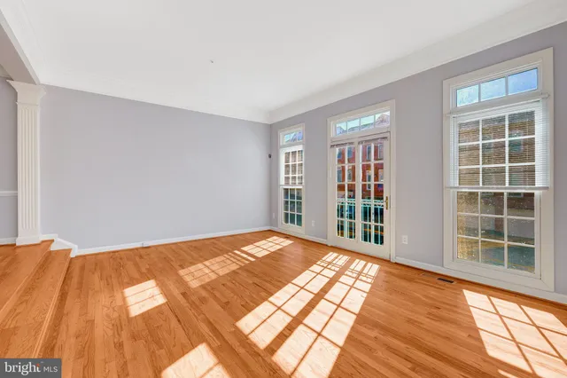 a view of a big room with wooden floor and windows in a room