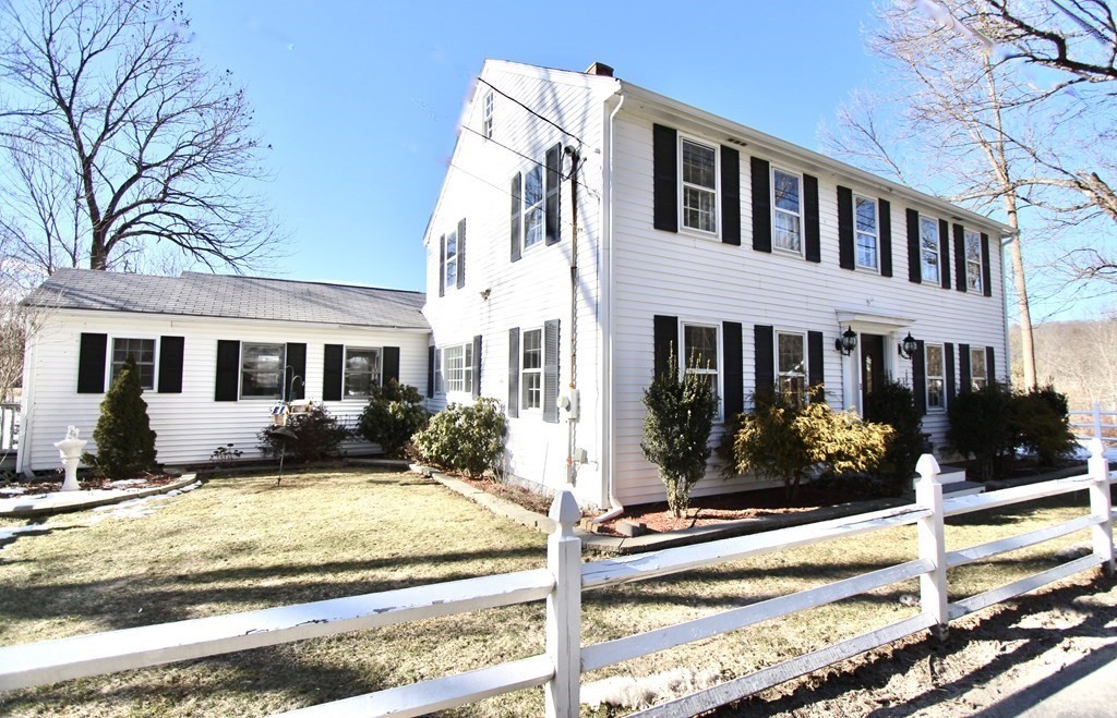 a view of a white house with large windows next to a road