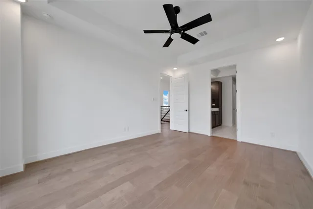an empty room with ceiling fan and window